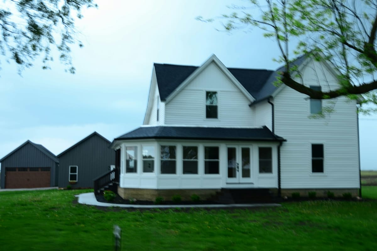 White farmhouse with lap siding on a green lawn
