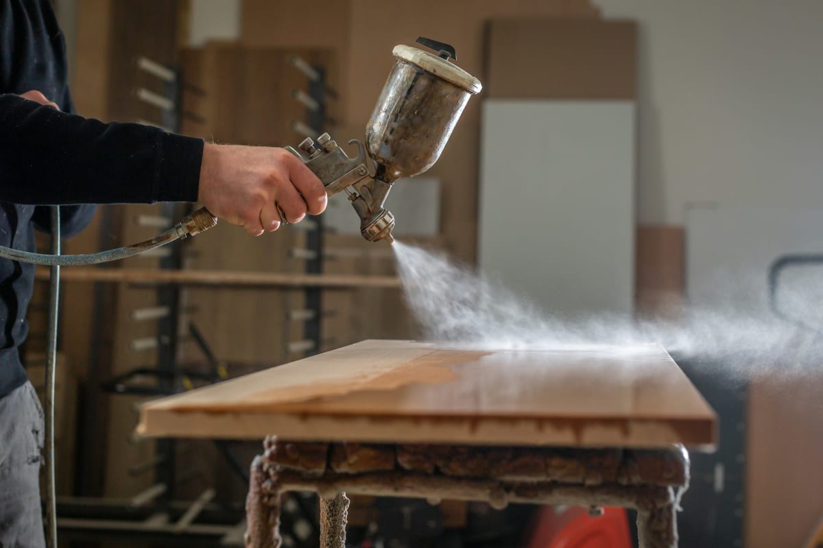 Spraying a fresh finish on a stripped table