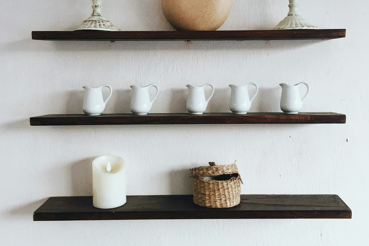 Dark wood shelves with white pitchers