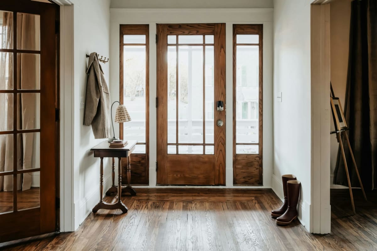 Bright entryway with a wood front door and glass sidelights