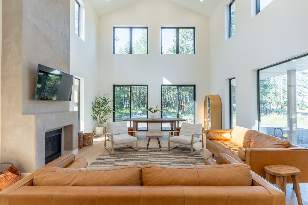 Bright living room with a wall of windows under a high ceiling
