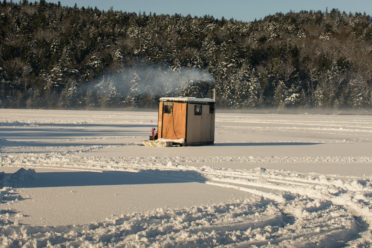 Ice-fishing shack on a frozen lake with heat rising