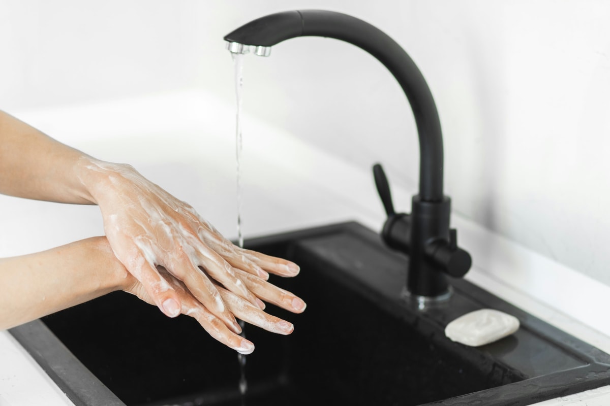 Washing hands at a black kitchen sink