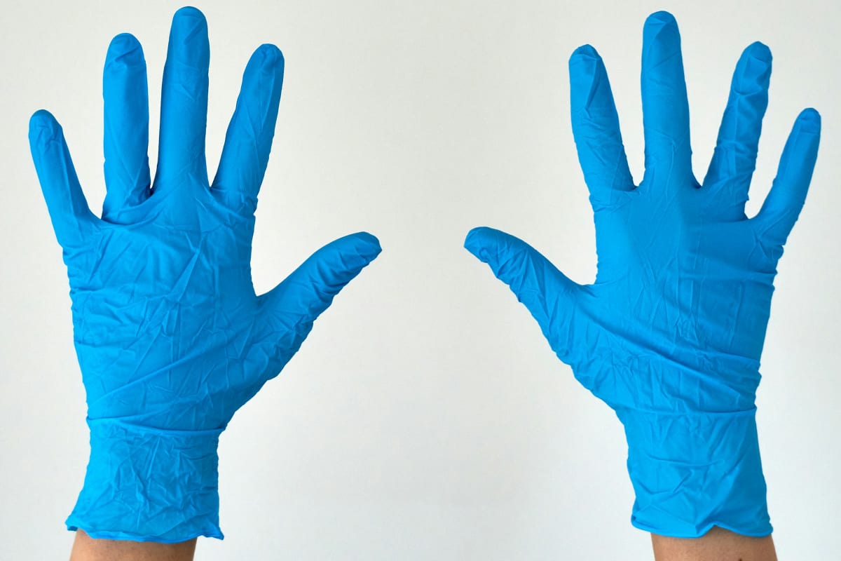Hands in blue nitrile gloves