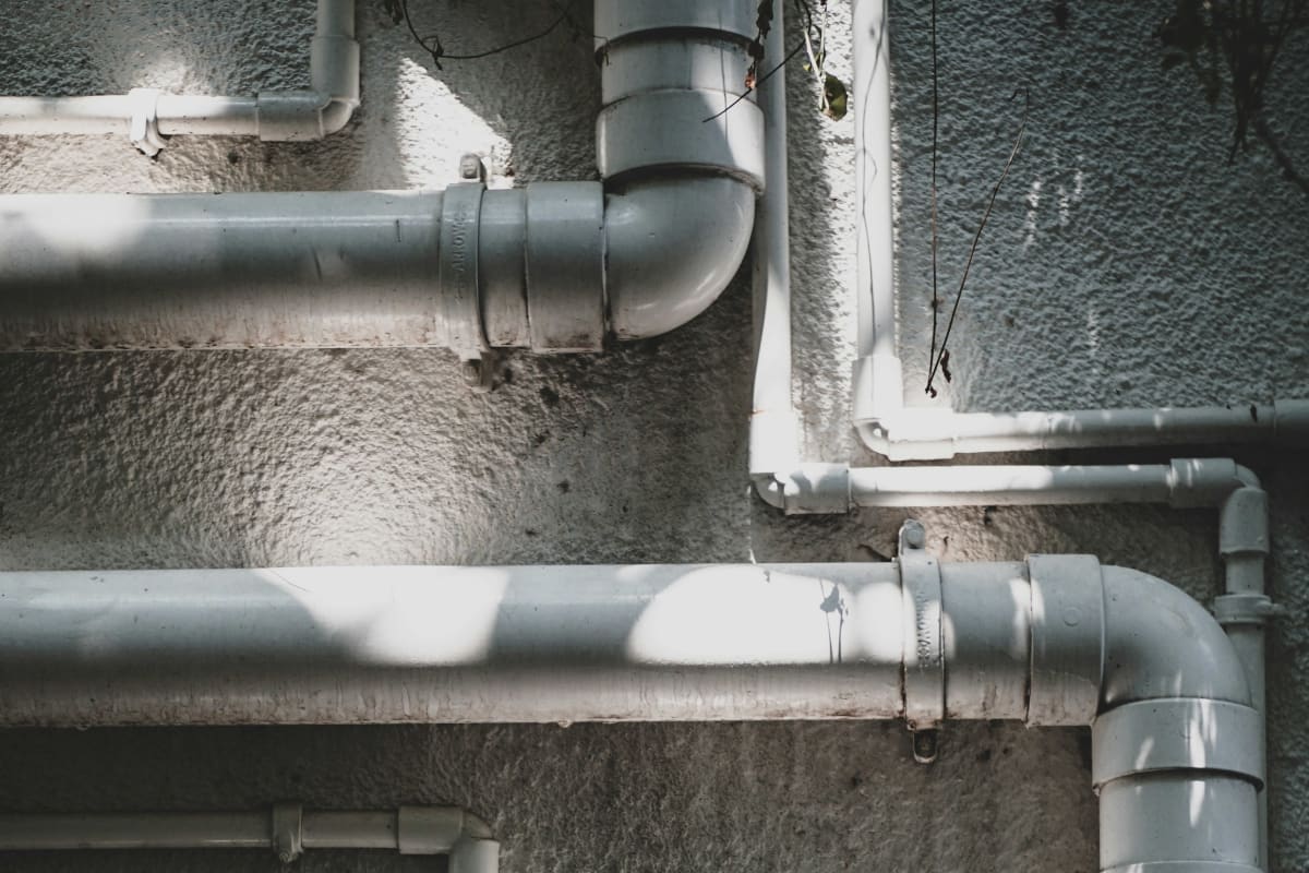 White PVC pipe run along a wall