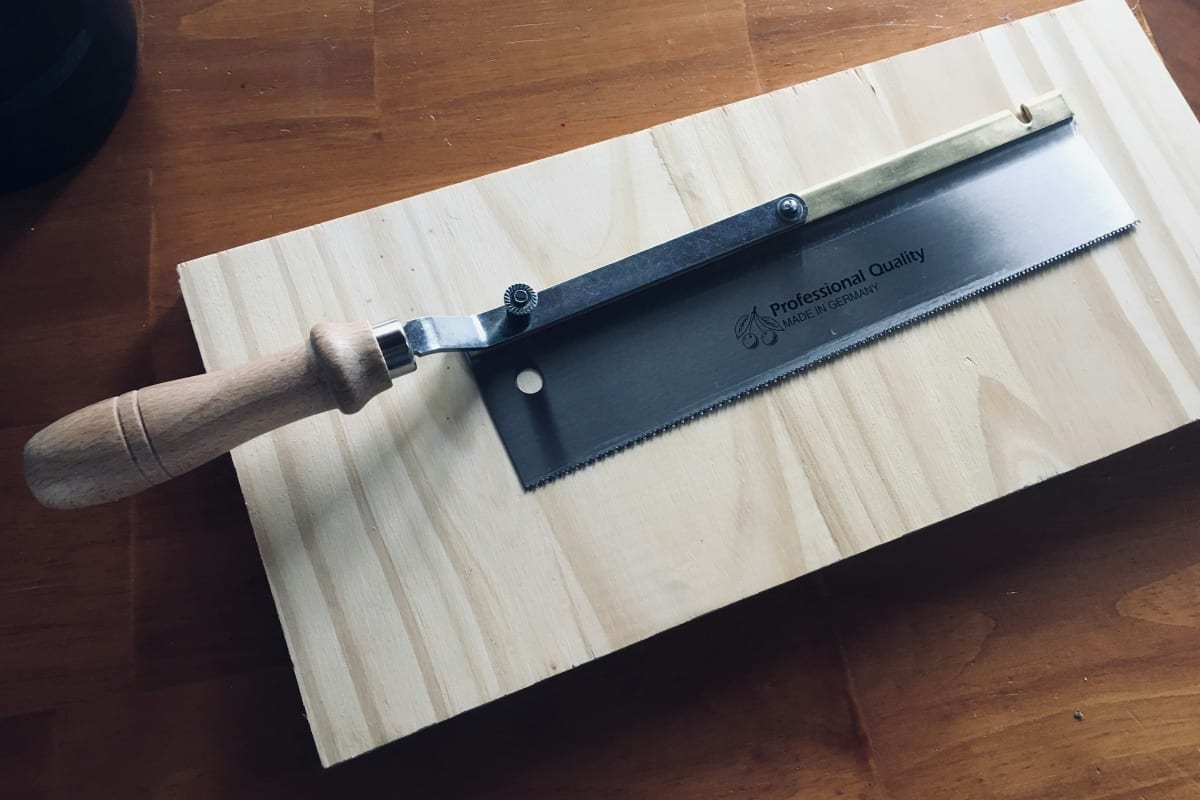 Fine-tooth hand saw on a board