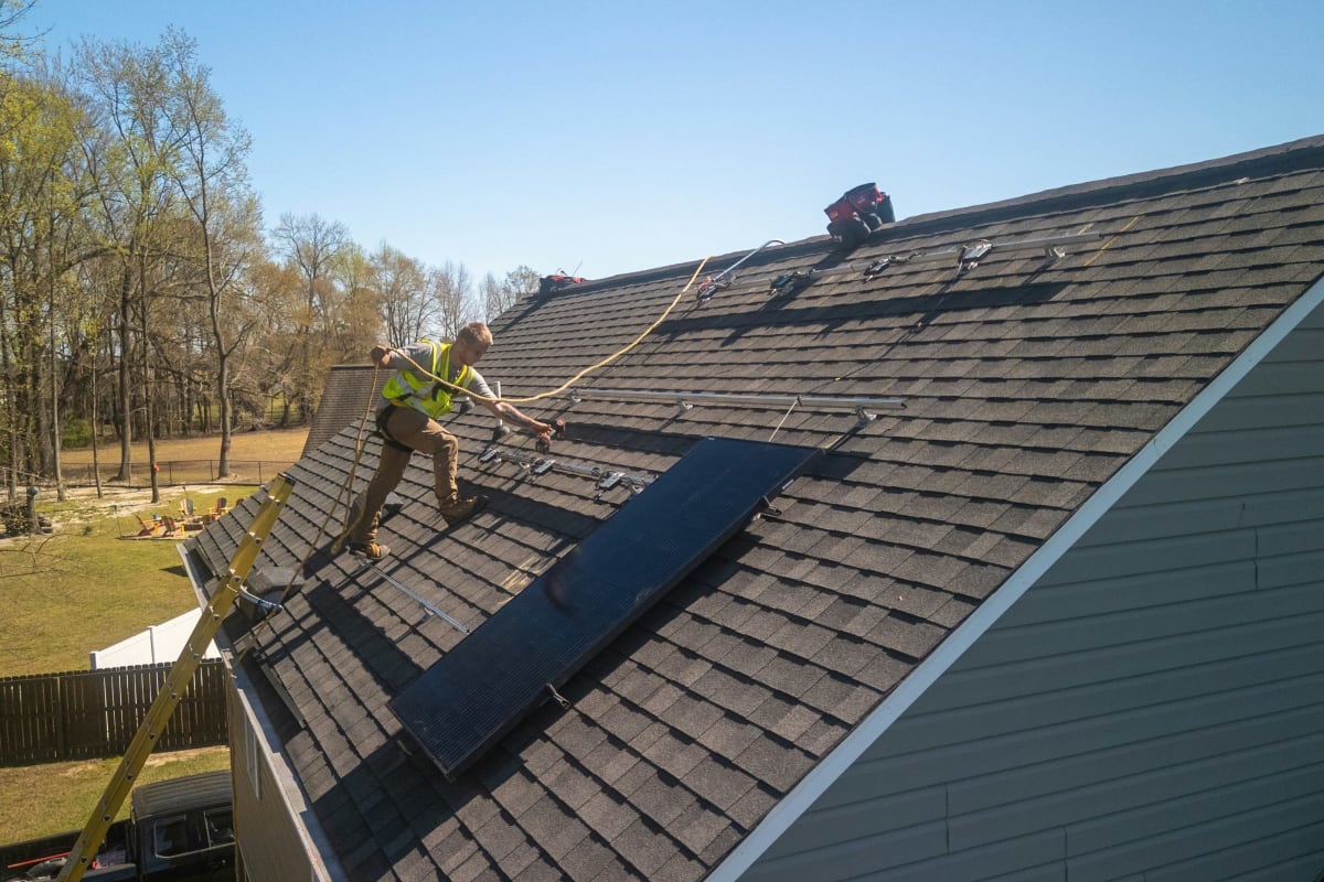 Roofers installing a shingle roof on a sunny day