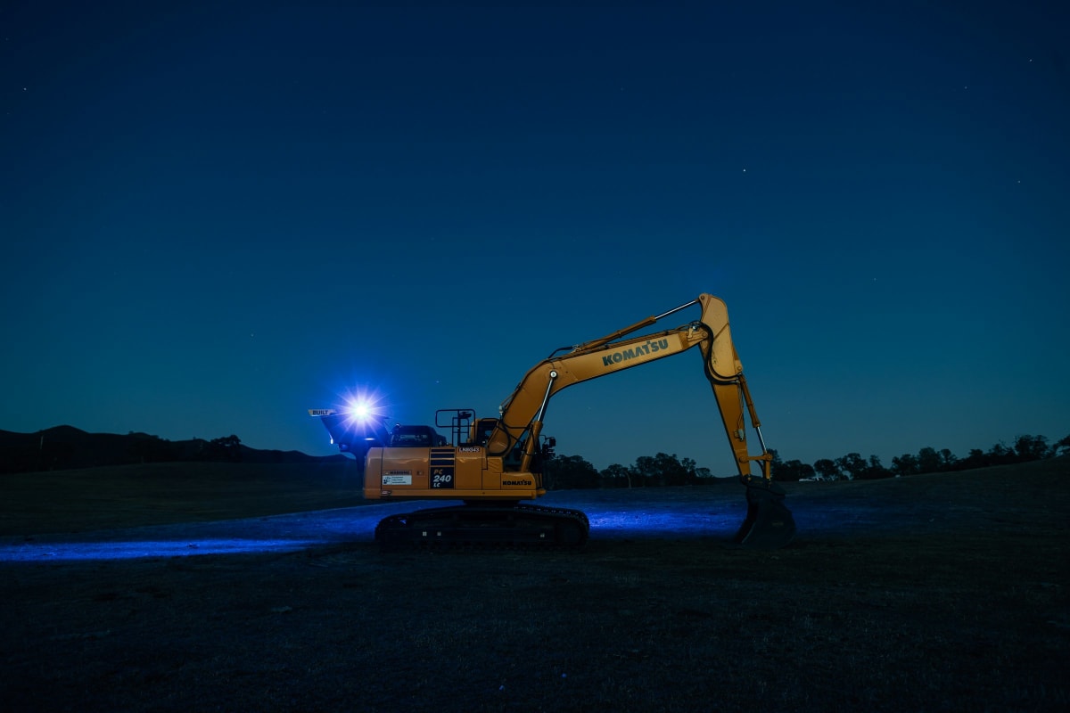 Excavator working under lights at night