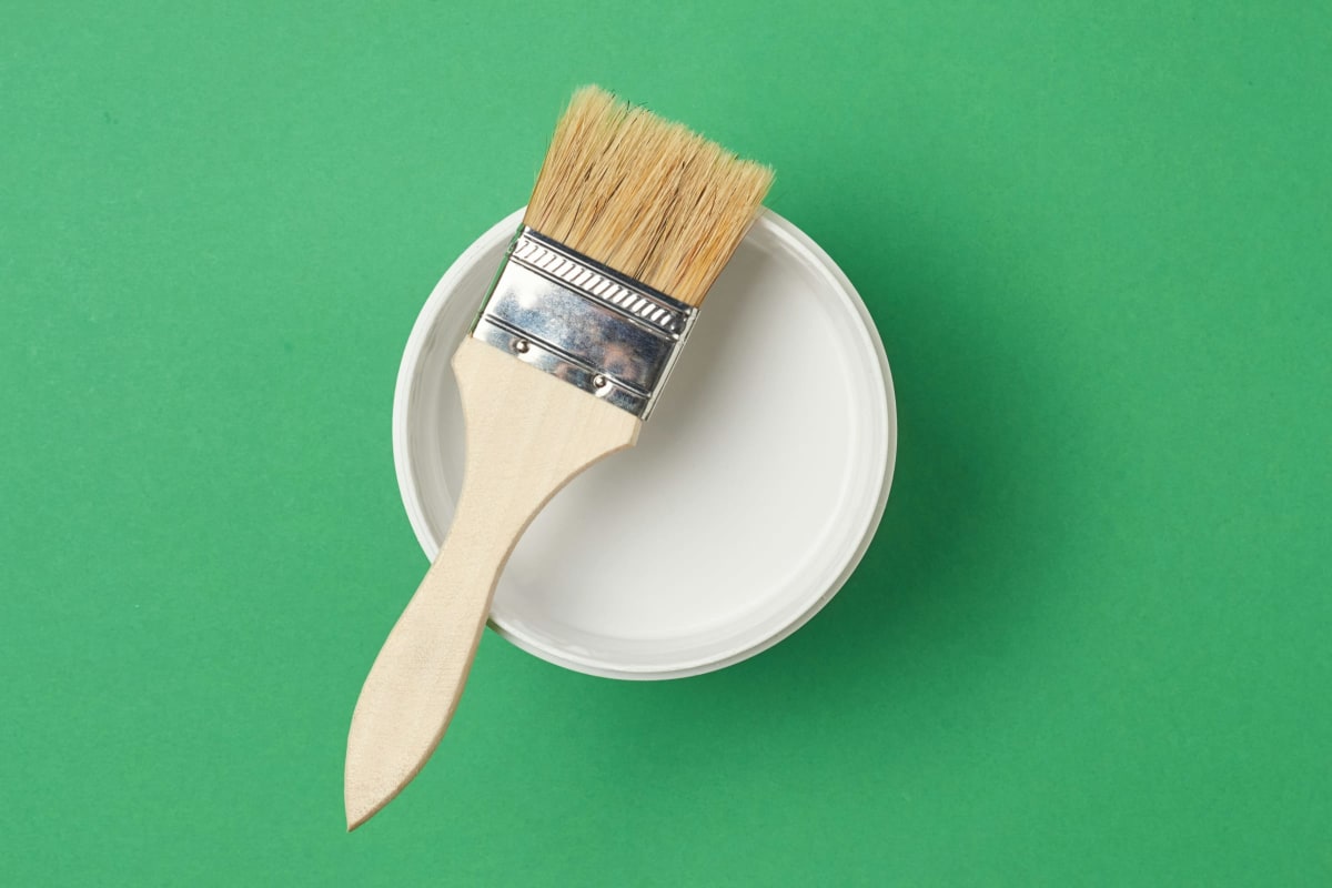 Paintbrush resting on a can of white paint