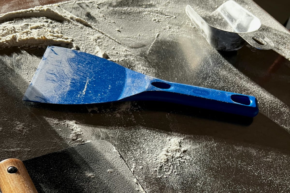 Putty knives on a dusty bench