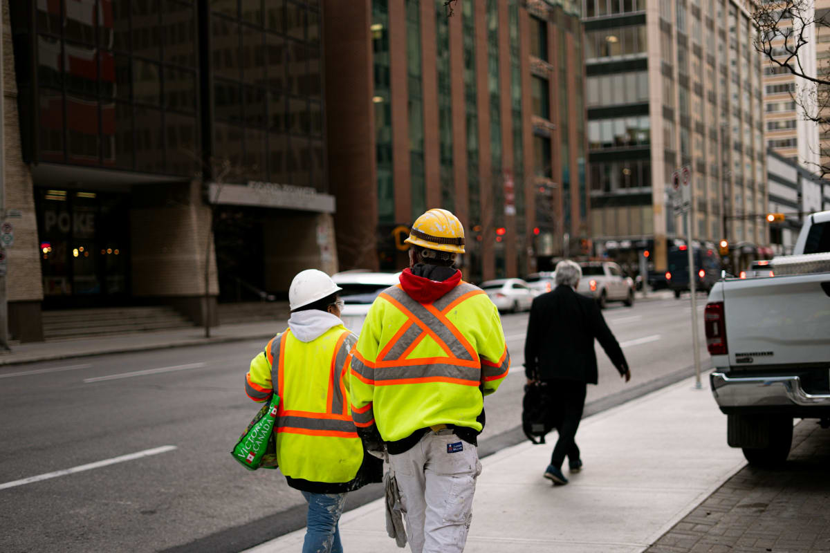 Workers in hi-vis vests on a city street