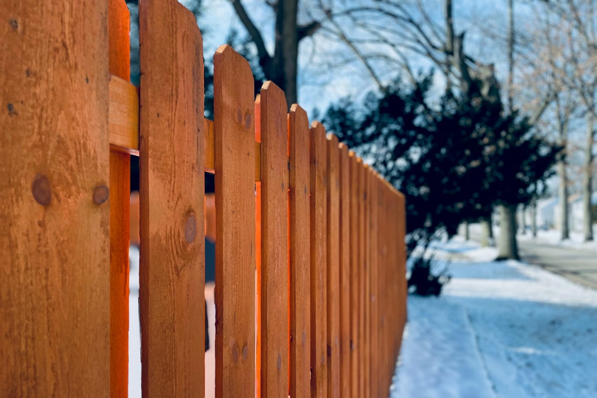 Stained wood fence in the snow
