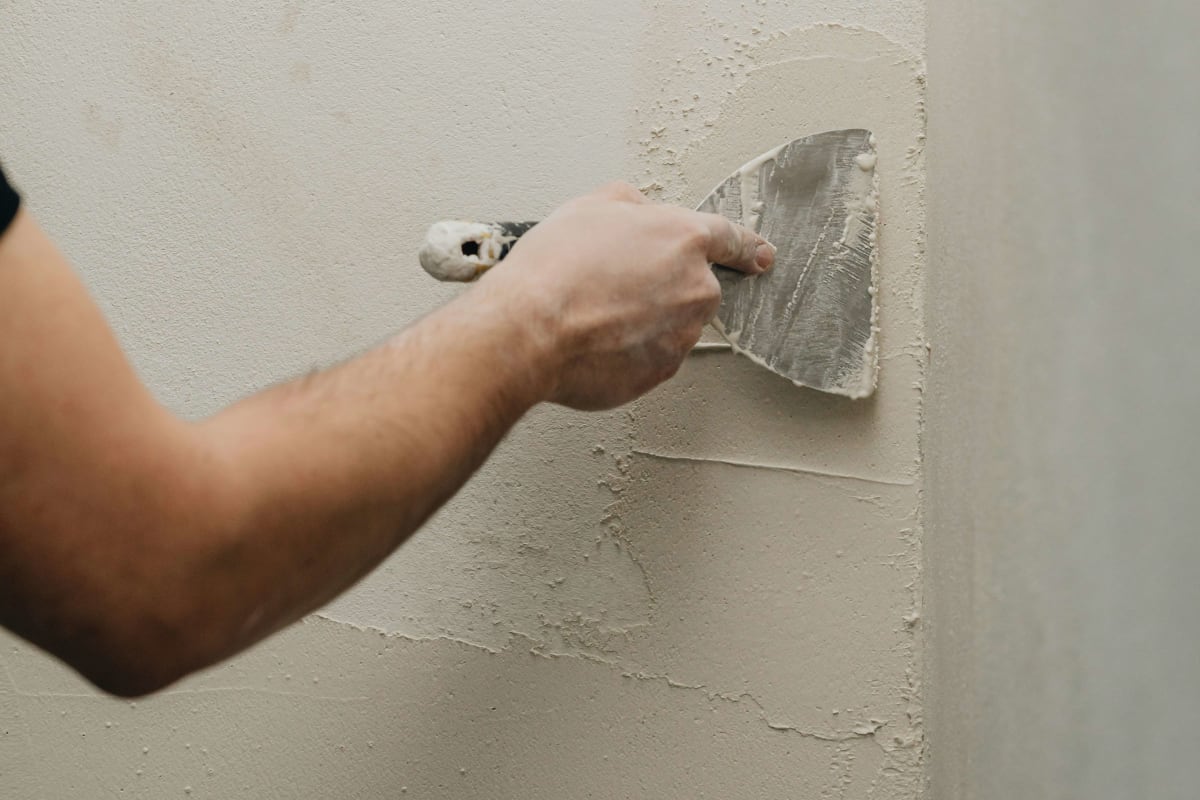 Spackling a wall with a putty knife
