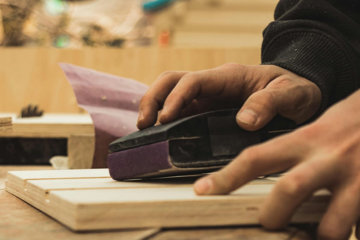 Sanding a board with a sanding block