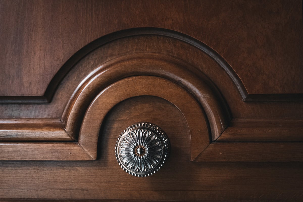 Round decorative knob on a carved wood cabinet door