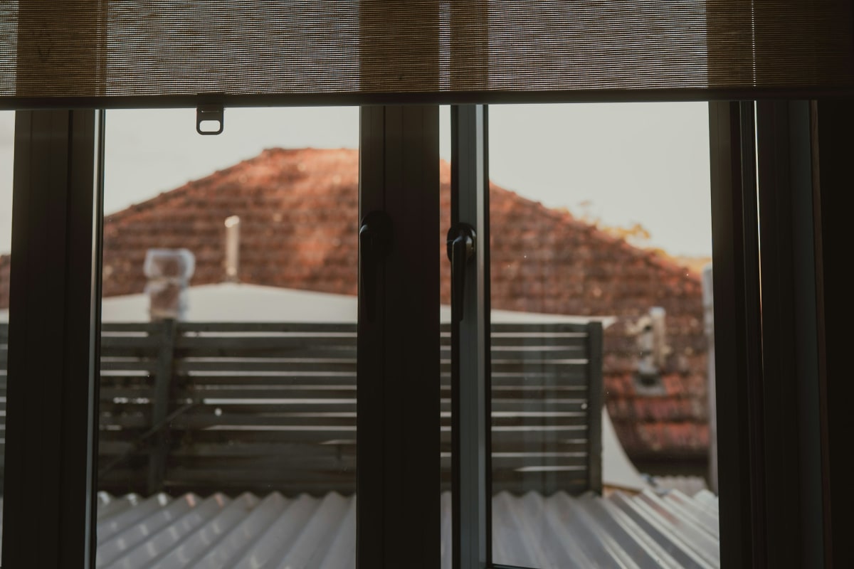 Woven roller shades over sliding doors