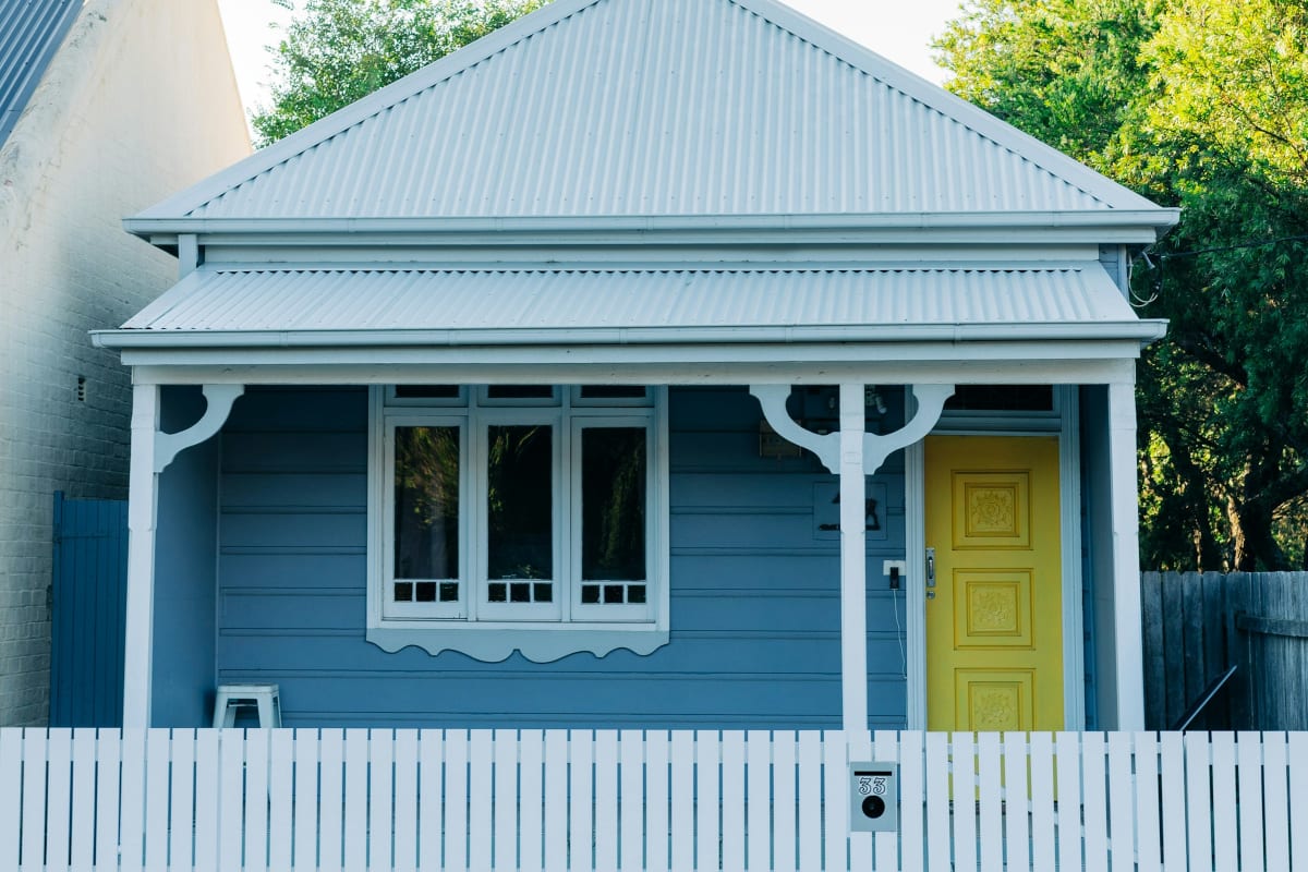 Blue cottage with a yellow front door