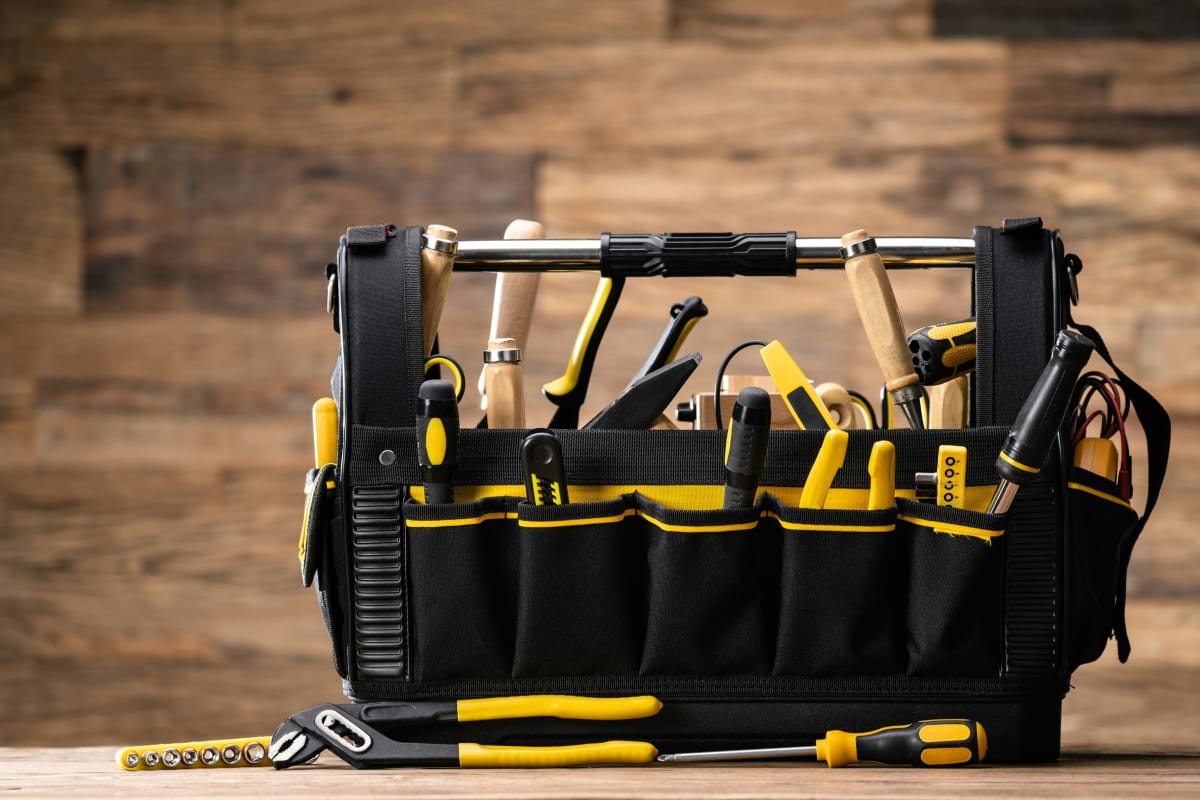 Yellow and black tool bag full of hand tools