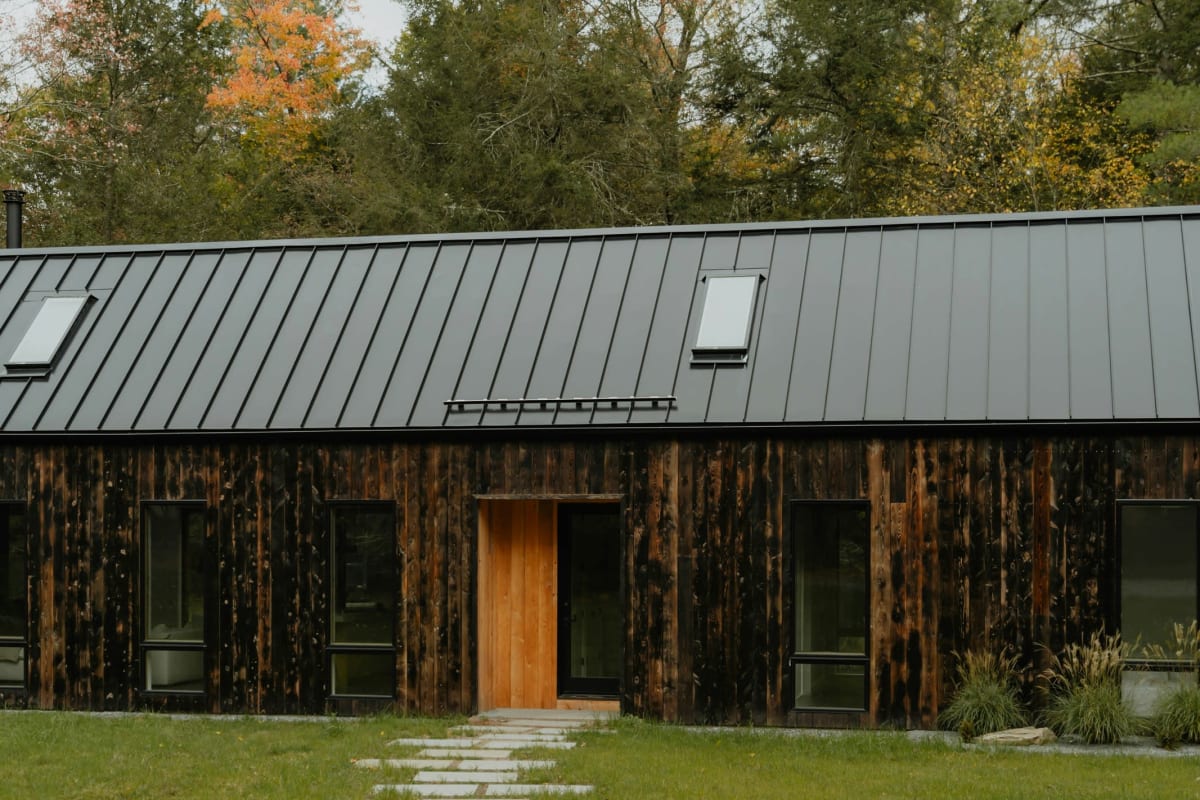 Dark standing seam metal roof on a wood home
