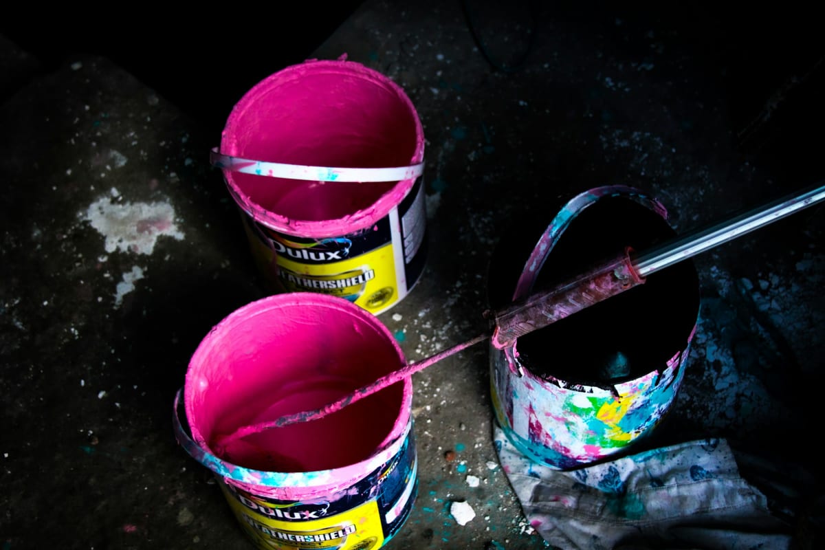 Stirring cans of bright paint