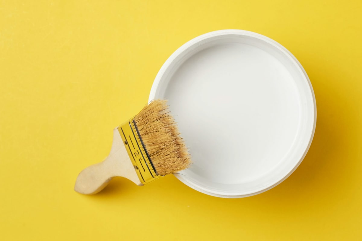 Paintbrush resting on a can of white paint