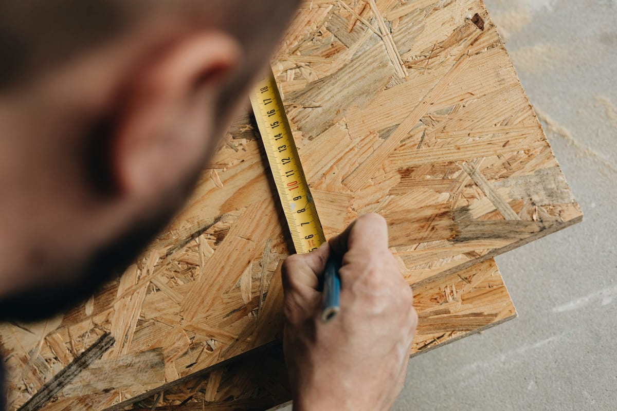 Marking a sheathing panel with a tape and pencil