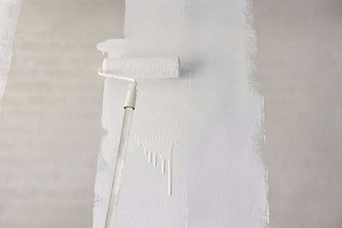 Rolling white paint over new drywall