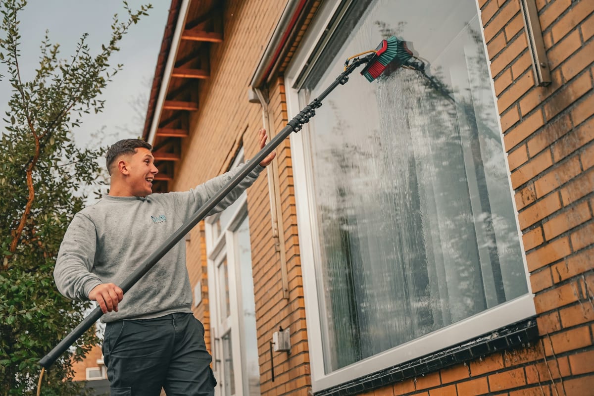 Washing a high window with an extension pole