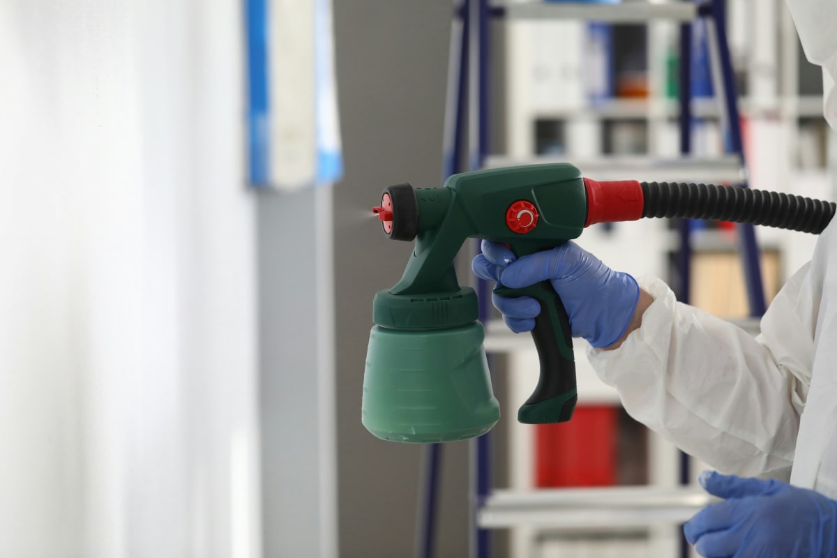 Handheld paint sprayer in action