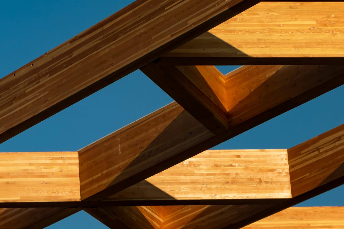 Glulam timber beams against a blue sky