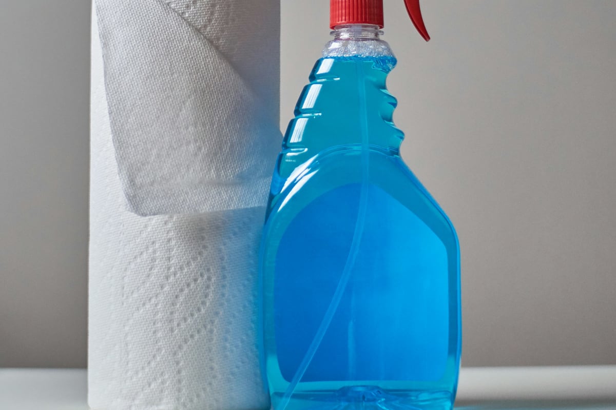 Spray bottle of blue cleaner and paper towels
