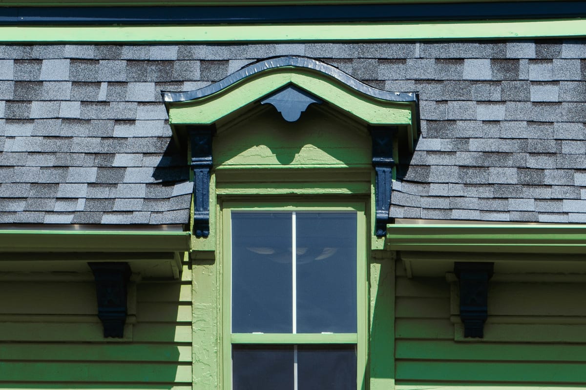 Crisp trim around a window on green lap siding