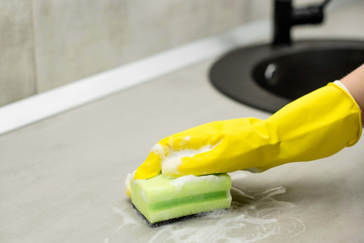 Scrubbing a counter with a sponge
