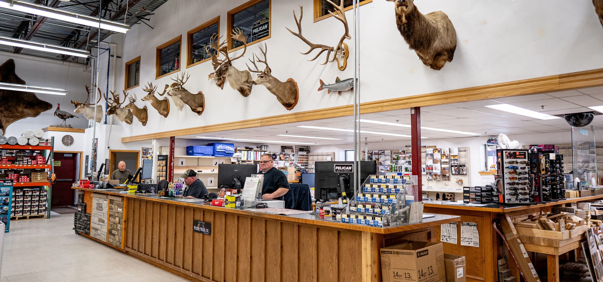 WBC employees under mounted animal trophies at rustic counter