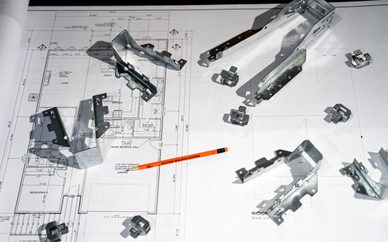 Metal framing brackets and structural connectors on architectural blueprints