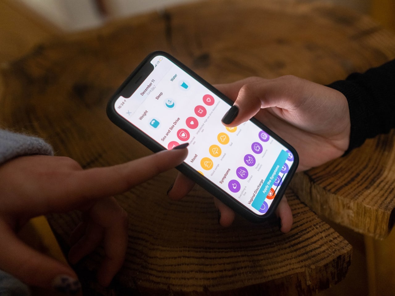 Woman using a cycle-tracking app on her phone