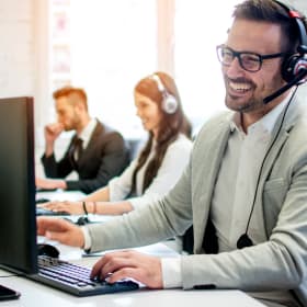 Personne souriante au téléphone dans un open space