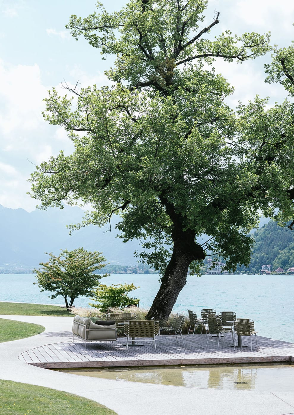 El césped y la terraza de la Auberge du Père Bise bajo un gran roble, a orillas del lago