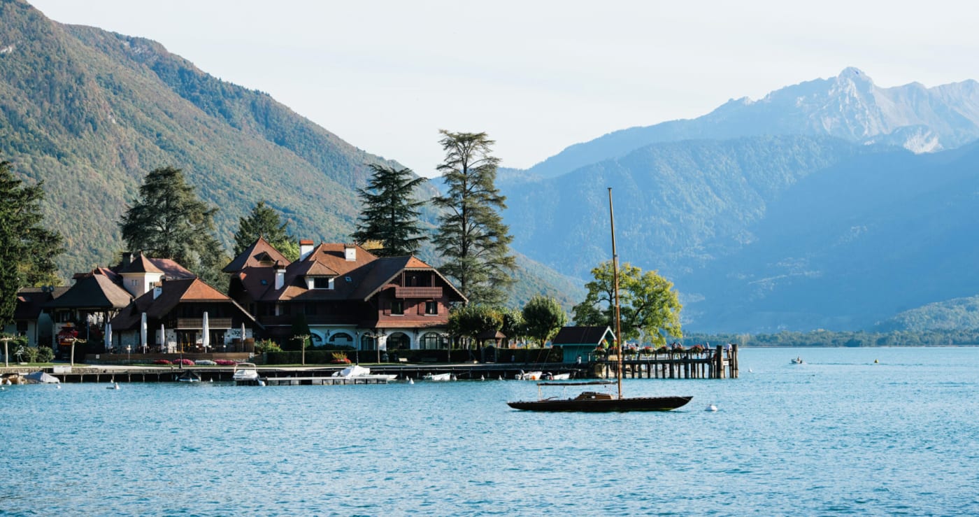 La Auberge du Père Bise vista desde el lago de Annecy, en Talloires, al pie de las montañas