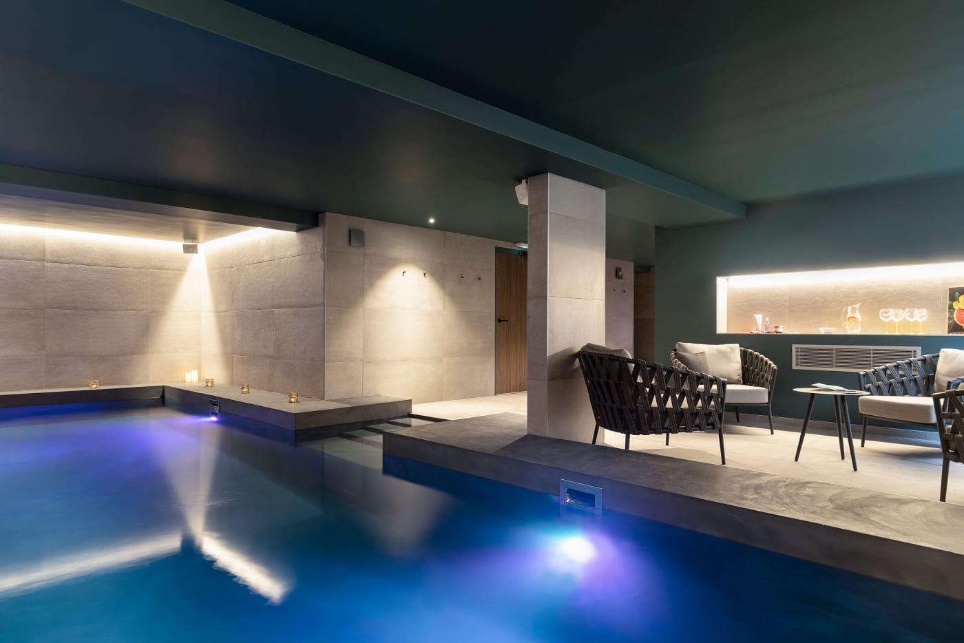 La piscina interior del spa del Black Bass, en Sevrier, con luz tenue y rincón de descanso
