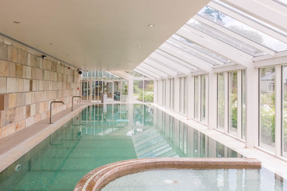 La piscine intérieure du Cara Spa de Lough Eske Castle, sous une verrière ouverte sur le jardin
