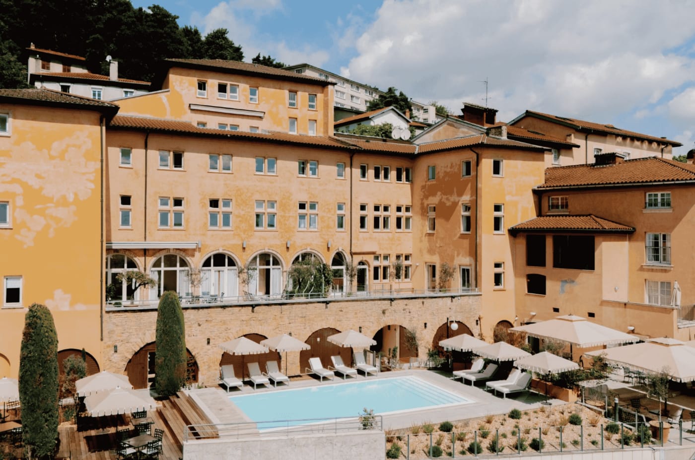 La piscine extérieure de la Villa Florentine, au pied de ses façades ocre sur la colline de Fourvière
