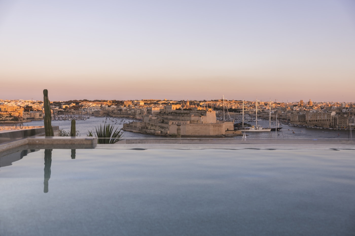 La piscina en la azotea del Solis Club del hotel Iniala Valletta al atardecer, con vistas al Grand Harbour