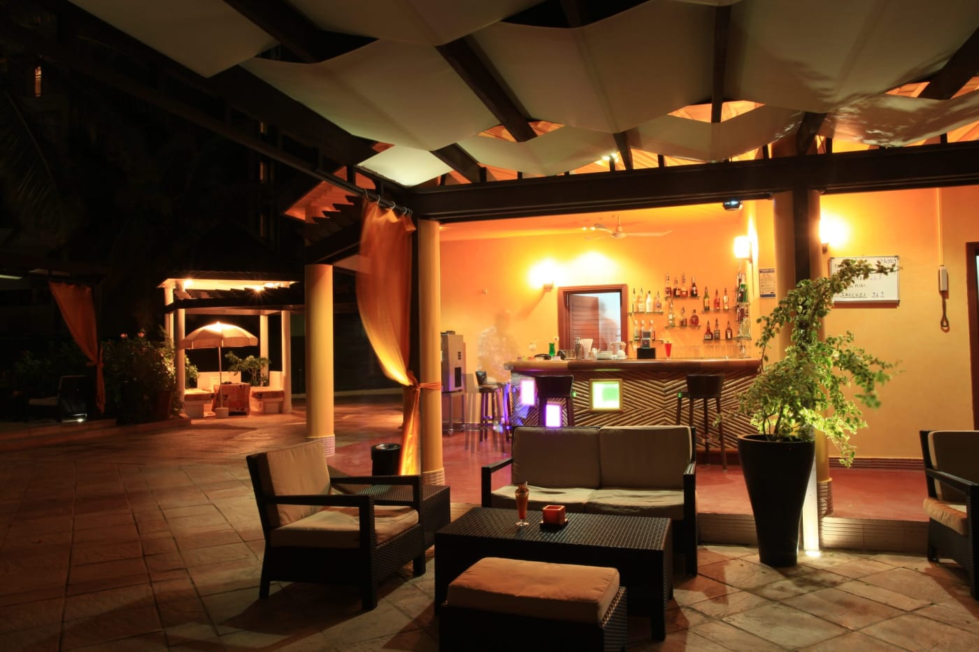 Bar no terraço iluminado do King Fahd Palace em Dakar, à noite