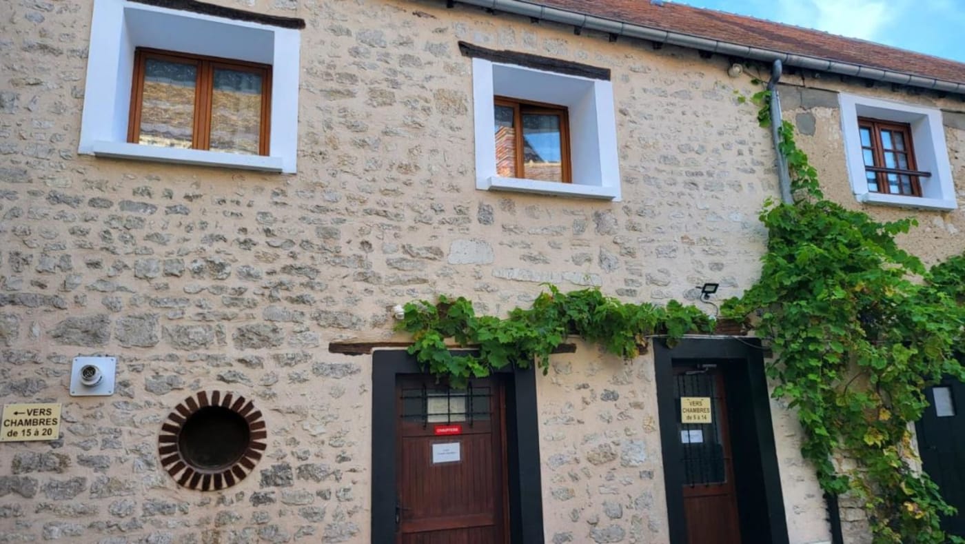 Façade en pierre et vigne vierge dans la cour de l'hôtel À la Vieille Halle