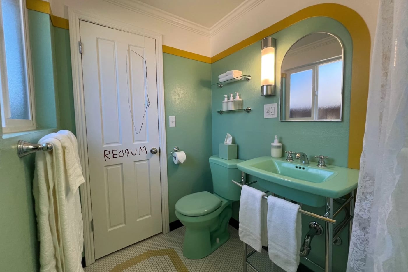 El baño verde agua de la cabaña de Big Bear Lake, con su puerta marcada REDRUM