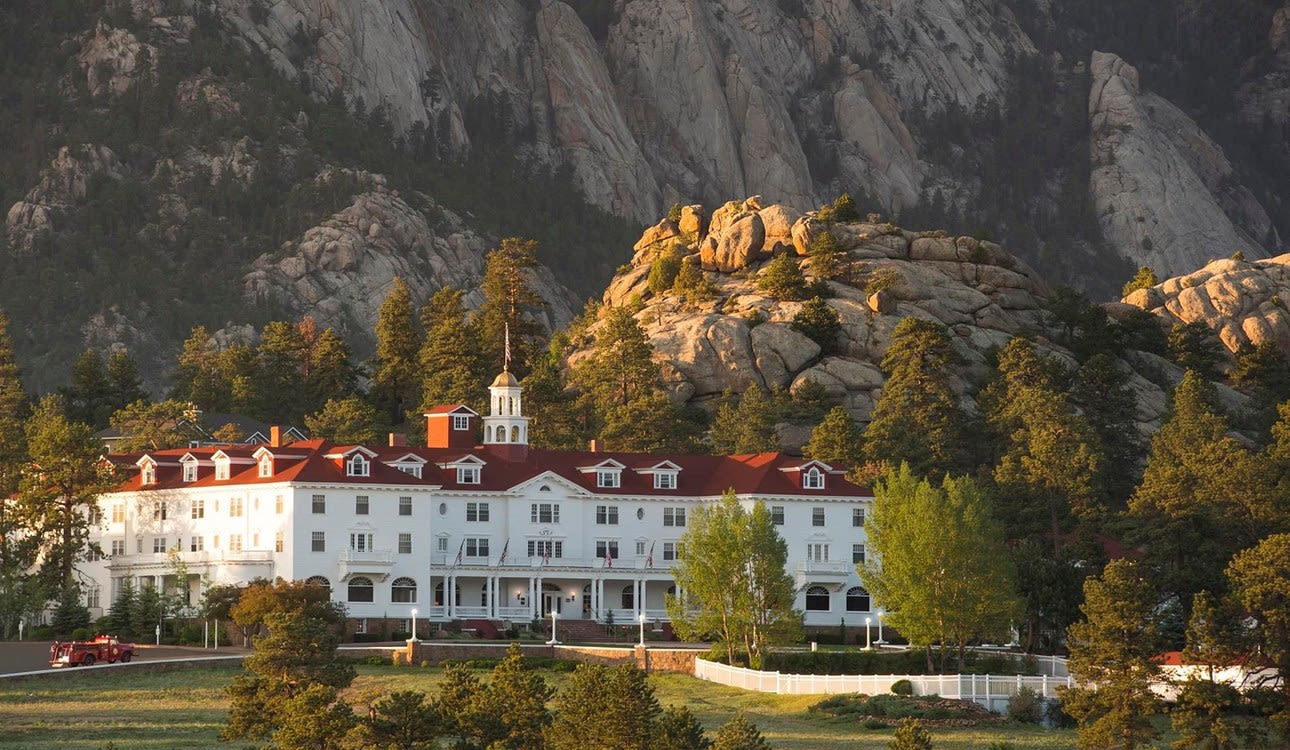 El Stanley Hotel, blanco y de tejados rojos, al pie de las montañas de Estes Park, en Colorado