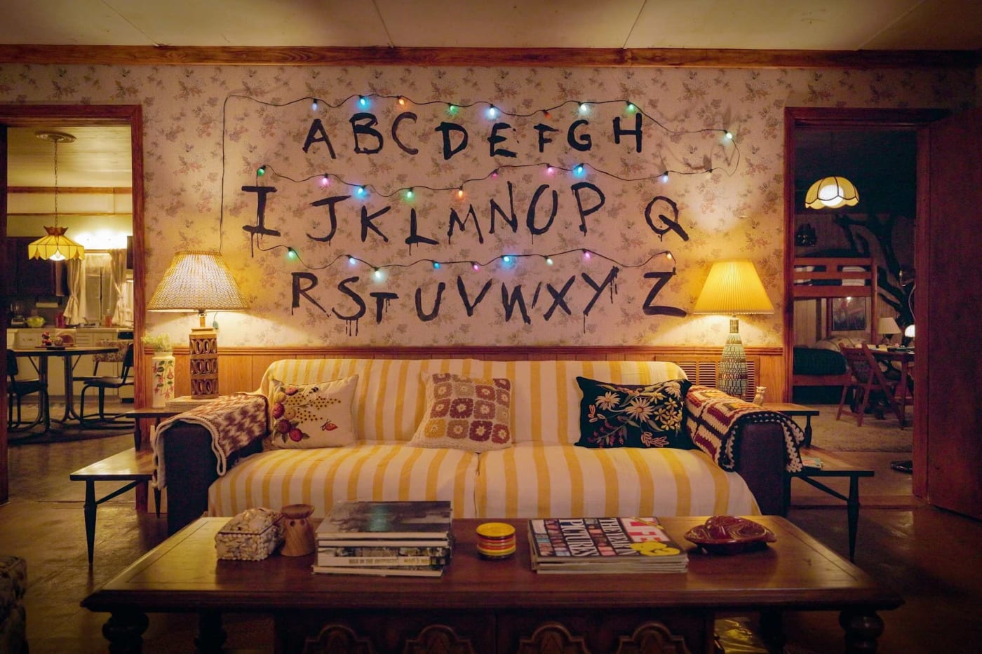 El salón de la casa de los Byers en Fayetteville, con el alfabeto pintado en la pared y las guirnaldas de luces