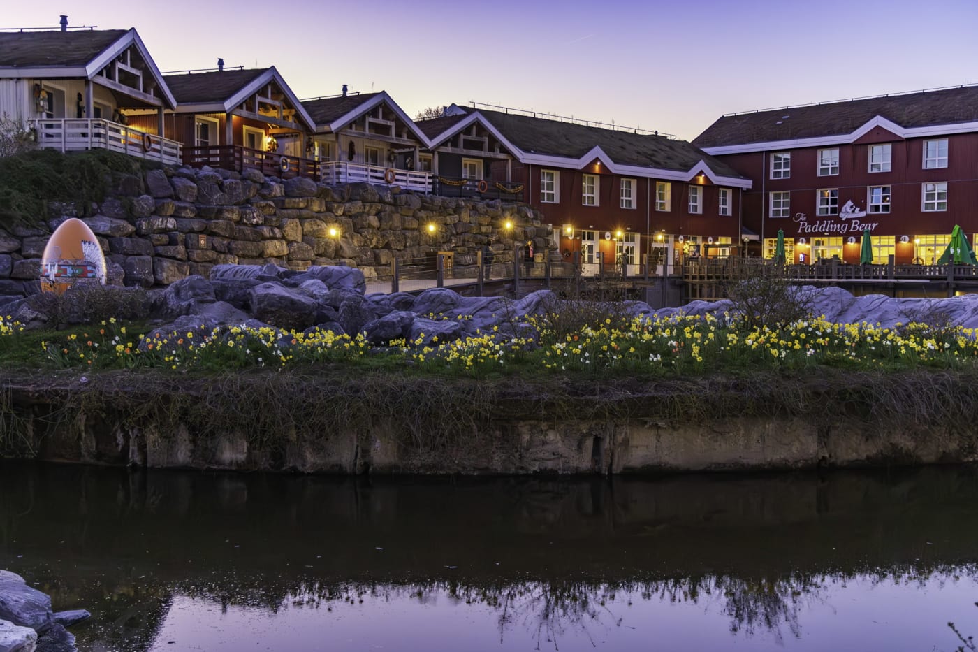 Das Paddling Bear Hotel mit seinen Holzfassaden in der Abenddämmerung, am Becken der Seelöwen