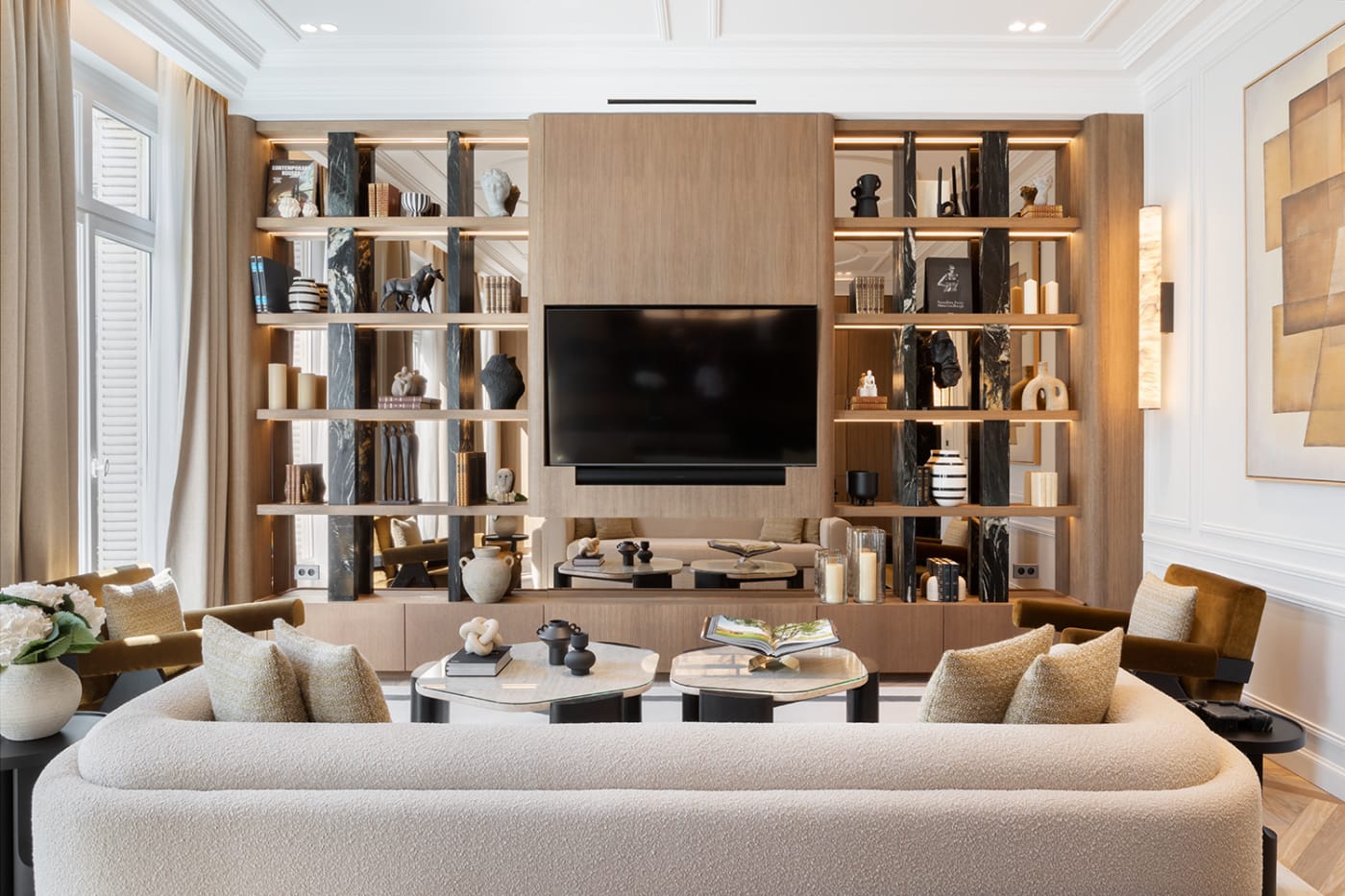 El salón del apartamento The Lander, con sofá crema y librería de pared, en el Triángulo de Oro